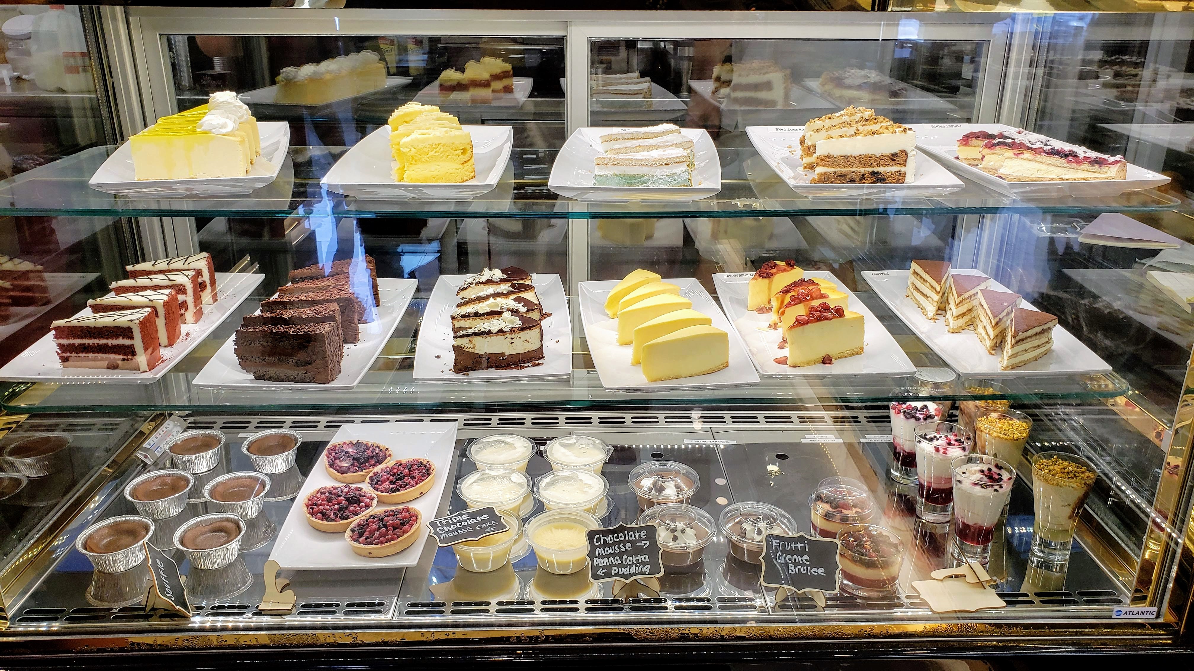 Dessert display case with cakes, brownies, and pastries