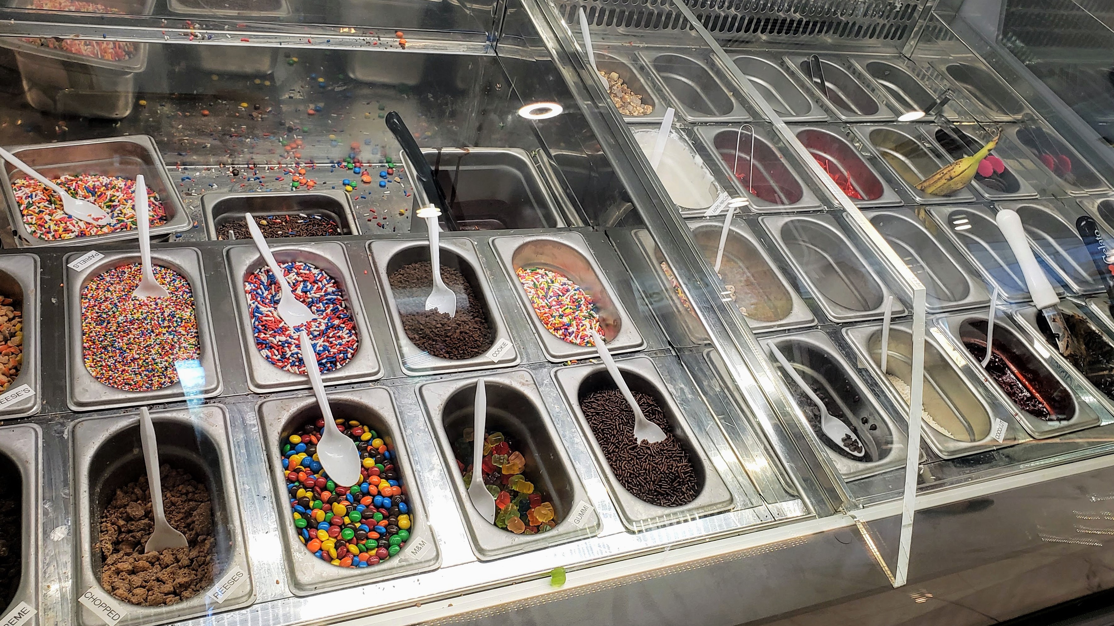 Gelato toppings bar with sprinkles, M&Ms, and chocolate chips