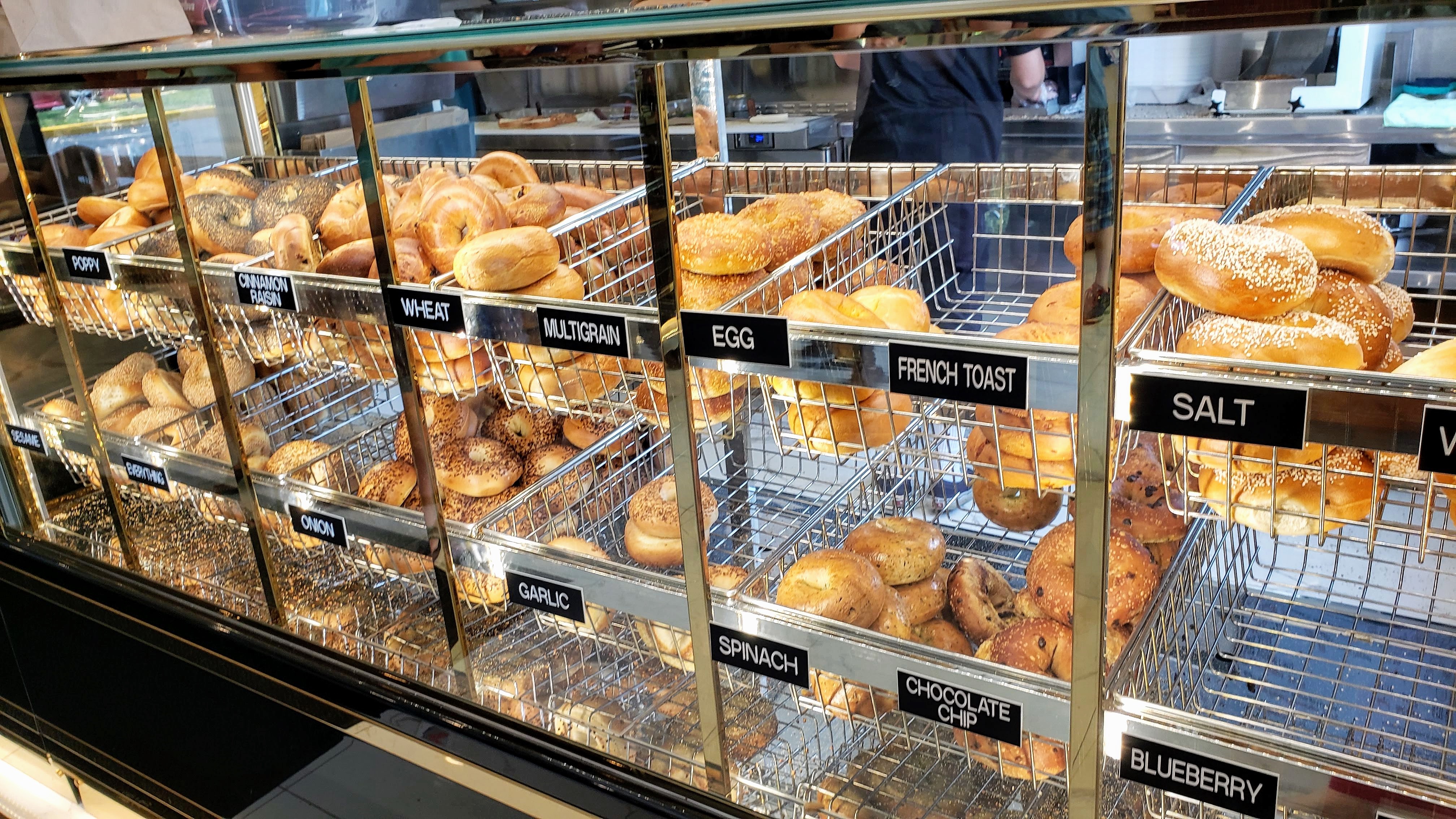 Display case of fresh bagel varieties including egg, French toast, garlic and more